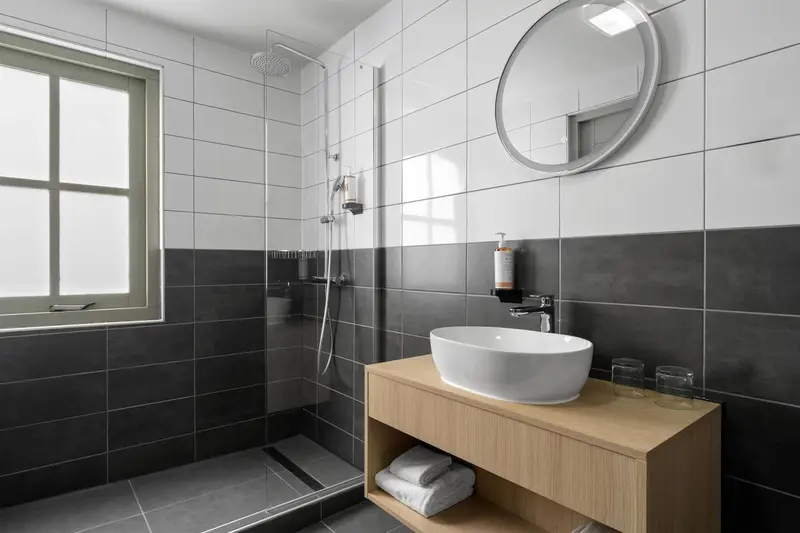 Une salle de bain moderne avec douche à l'italienne et vasque sur meuble.