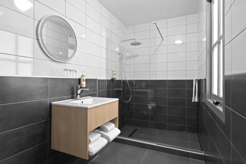 Une salle de bain moderne avec douche à l'italienne et carrelage blanc et gris.