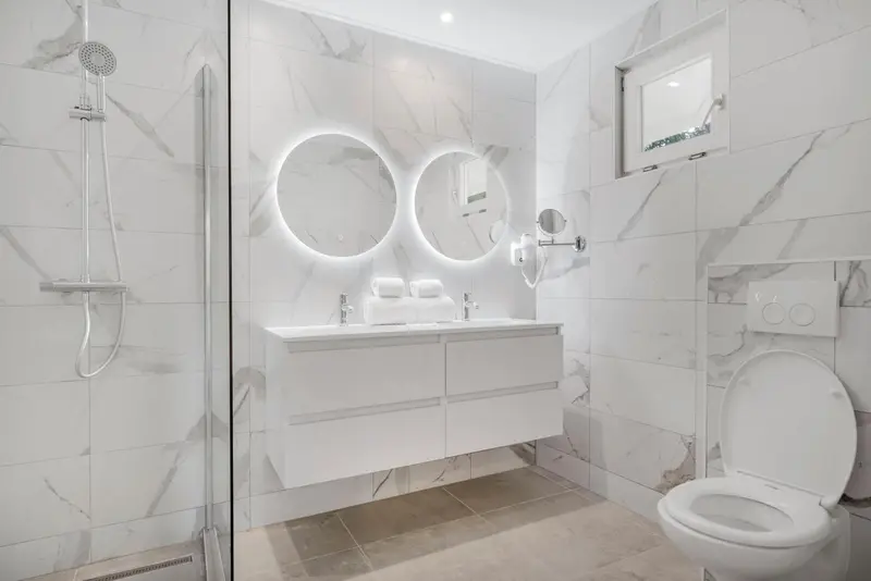 Une salle de bain moderne avec douche à l'italienne et vasque double.