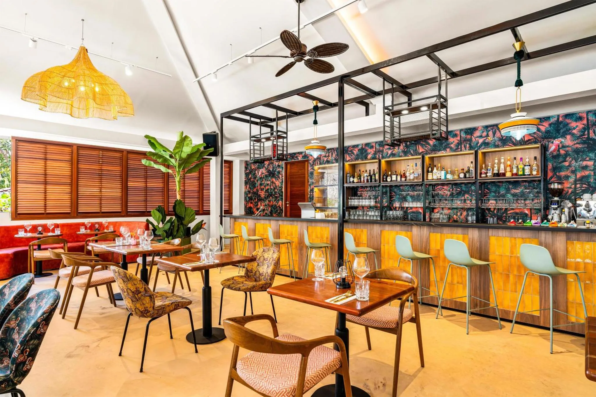 Une salle de restaurant lumineuse avec des tables et un comptoir de bar.