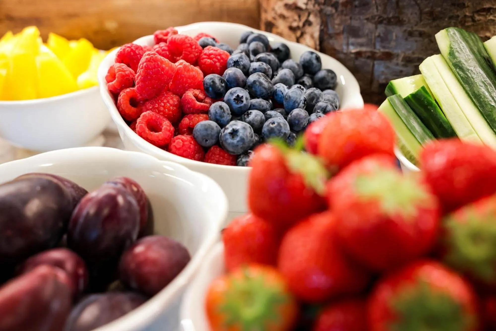 Assortiment de fruits frais dans des bols blancs.