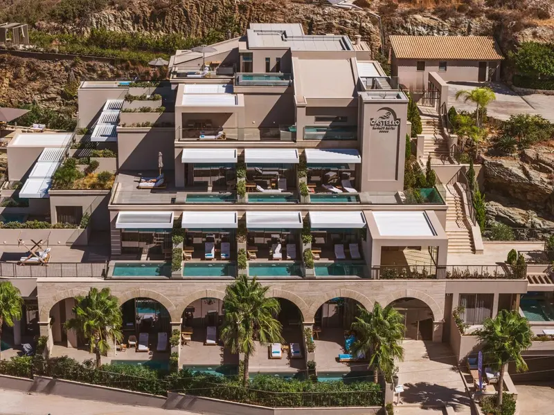 Vue aérienne d'un complexe hôtelier blanc avec des terrasses et des piscines.