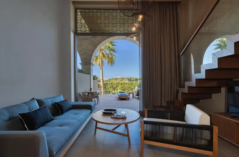 Un salon moderne s'ouvre sur une terrasse avec vue sur la végétation.