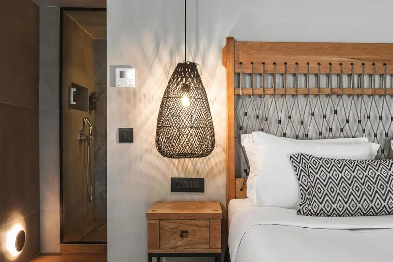 Une chambre lumineuse avec un lit recouvert d'oreillers blancs et d'un coussin décoratif.