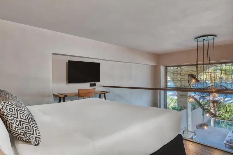 Une chambre lumineuse avec un grand lit et un bureau.