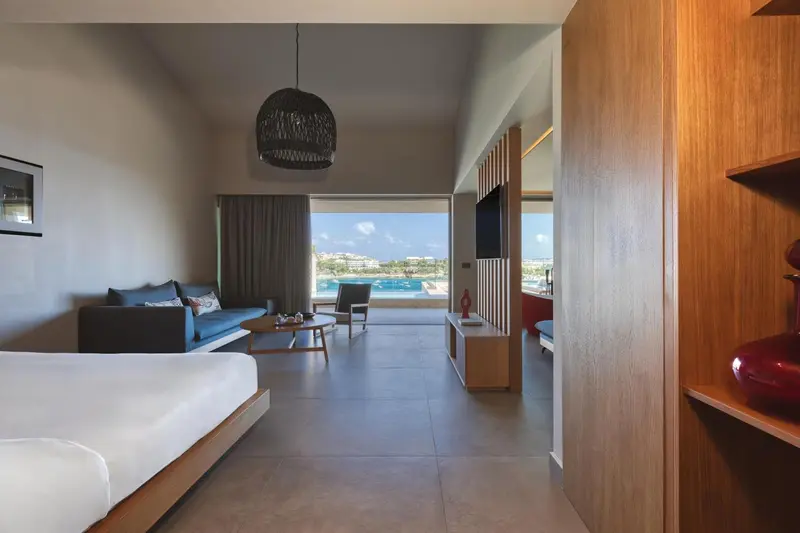 Une chambre lumineuse avec un canapé et une vue sur une piscine.