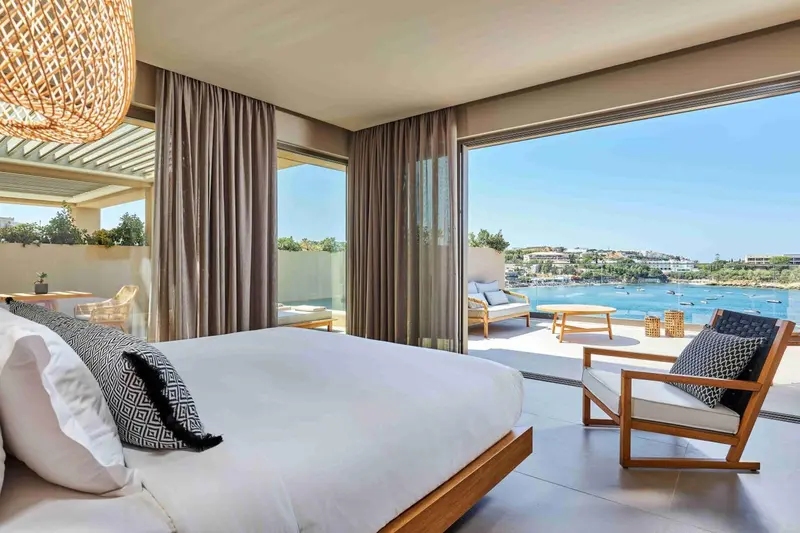 Une chambre lumineuse s'ouvre sur une terrasse avec vue sur la mer.