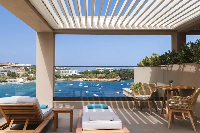 Terrasse avec mobilier de détente et vue sur la mer.
