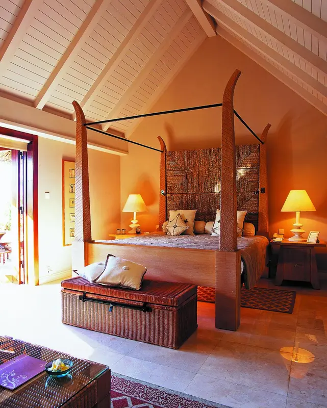 Une chambre lumineuse avec un grand lit à baldaquin et une décoration chaleureuse.