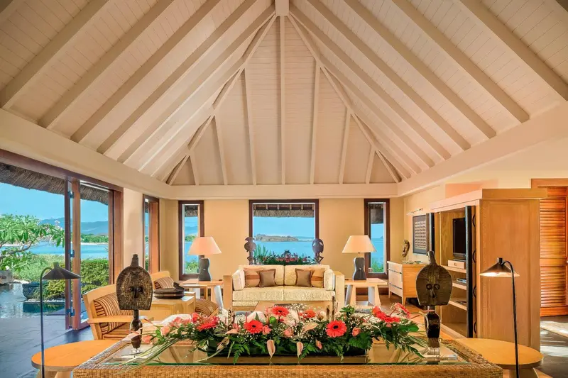 Un salon lumineux avec une décoration florale et une vue sur la mer.