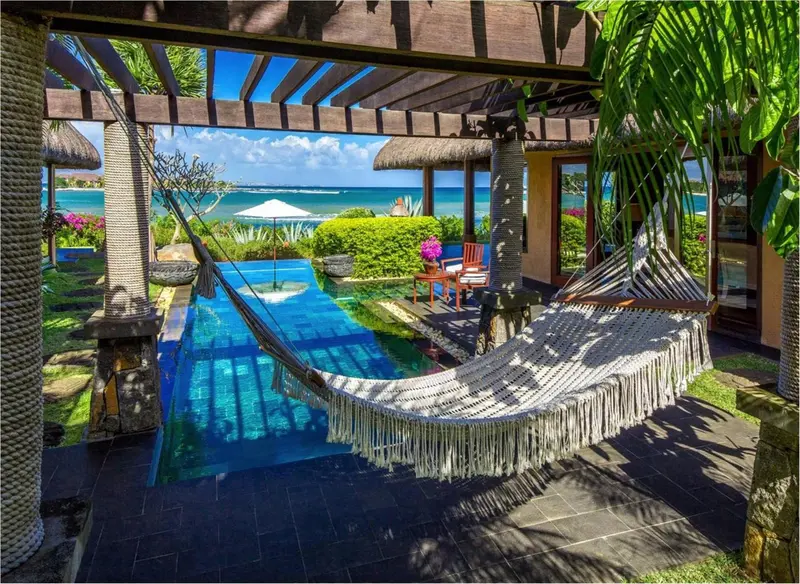 Une piscine avec un hamac et une vue sur la mer.