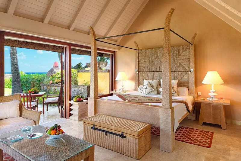 Une chambre lumineuse avec un grand lit à baldaquin donnant sur une vue tropicale.