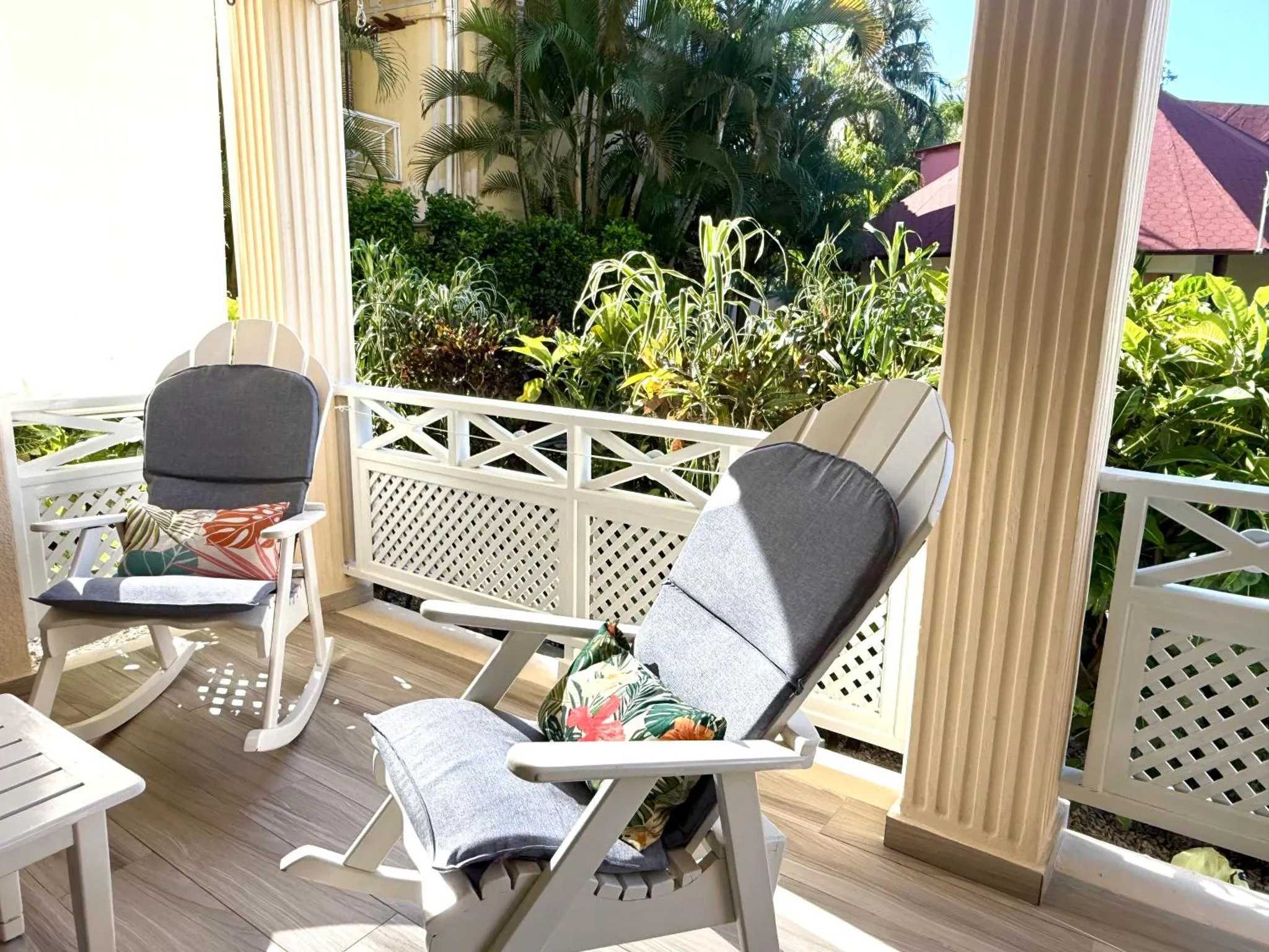 Deux fauteuils en bois confortables invitent à la détente sur une terrasse ombragée.