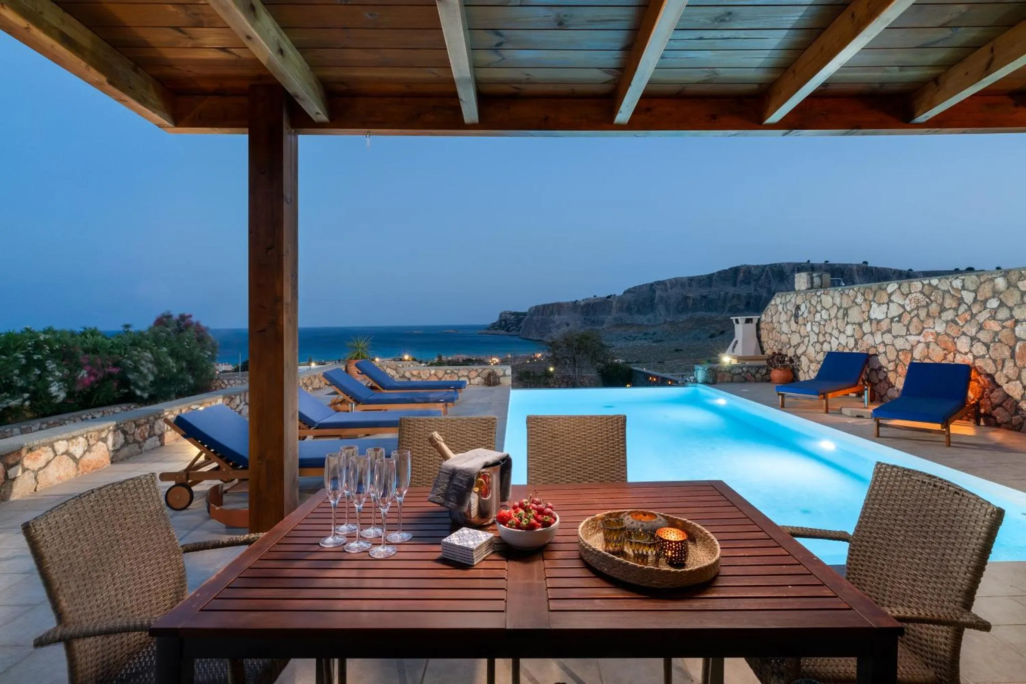 Terrasse avec table à manger et piscine face à la mer.