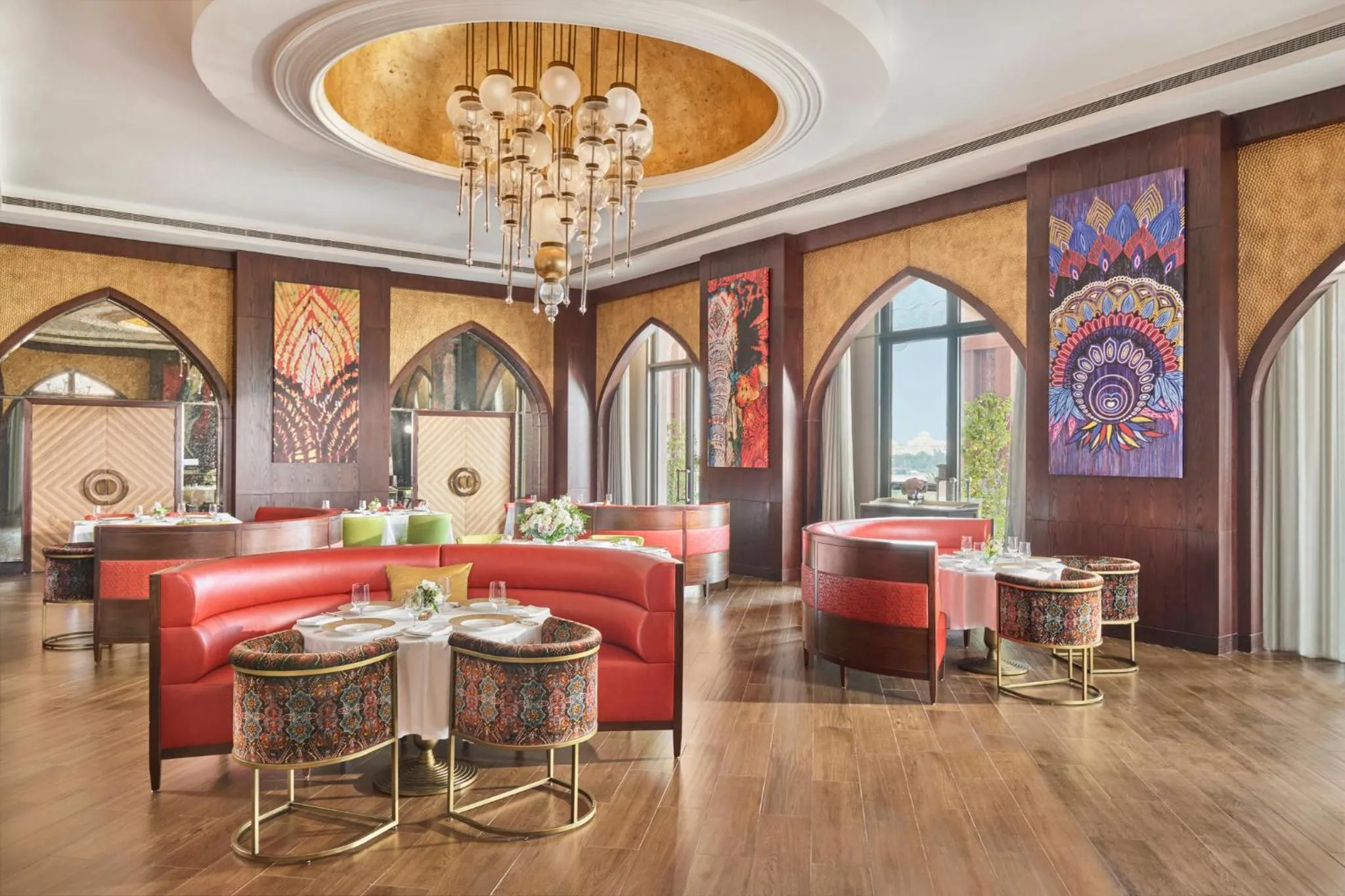 Une salle de restaurant luxueuse avec des tables dressées et un décor opulent.