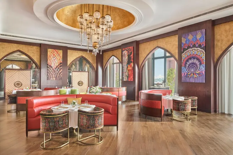 Une salle de restaurant luxueuse avec des tables dressées et un décor opulent.
