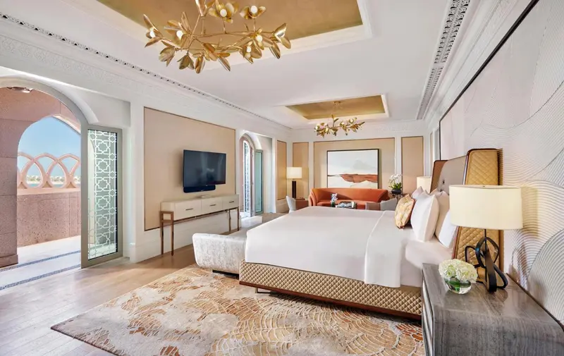 Une chambre lumineuse avec un grand lit et un canapé orange.