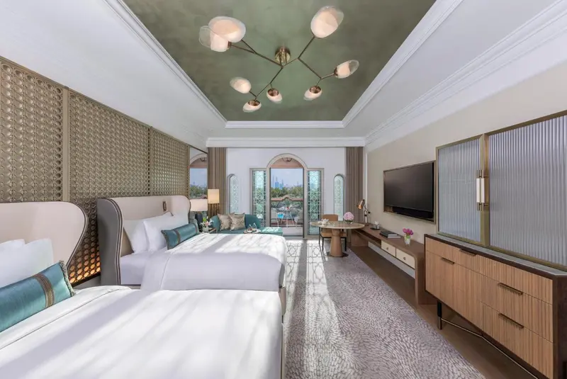 Chambre lumineuse avec deux lits et une décoration soignée.