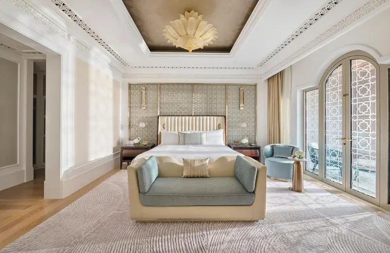 Une chambre lumineuse avec un grand lit et un coin salon.