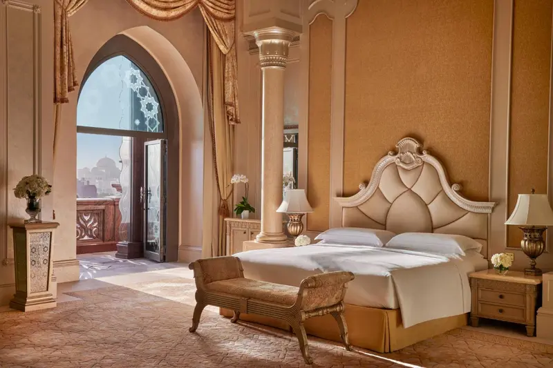 Une chambre lumineuse avec un grand lit et un décor opulent.