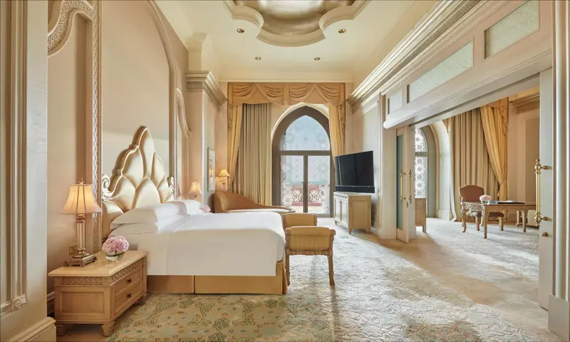 Une chambre spacieuse avec un grand lit à baldaquin et un coin salon.