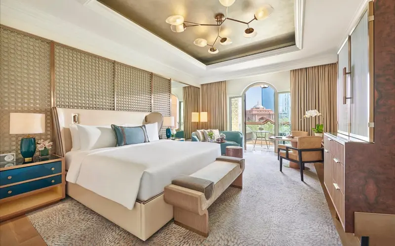 Une chambre lumineuse avec un grand lit et un coin salon.