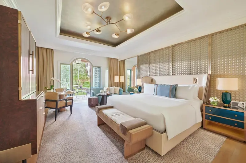 Une chambre lumineuse avec un grand lit et un coin salon.