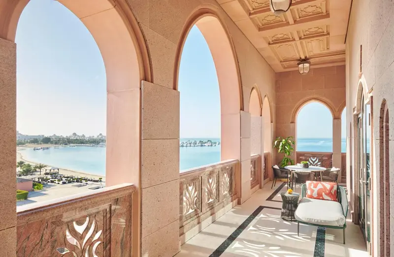 Balcon avec mobilier d'extérieur donnant sur une plage et la mer.