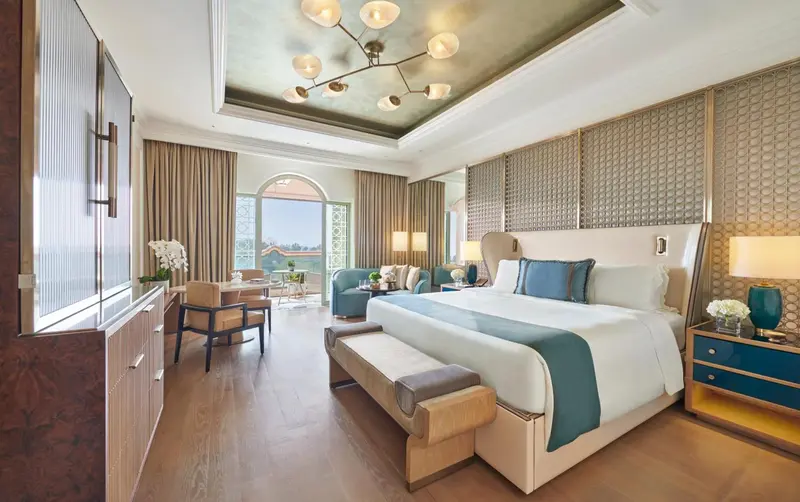 Une chambre lumineuse avec un grand lit et un coin salon.