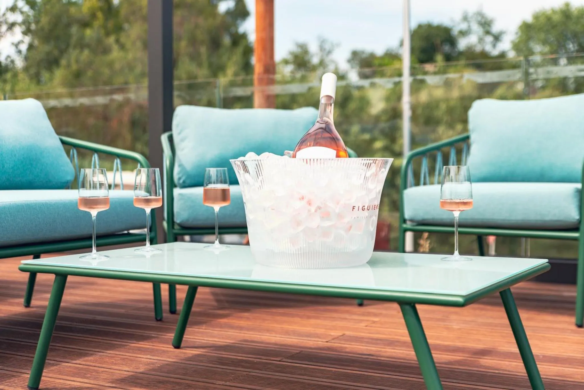 Une table basse avec des boissons et des verres sur une terrasse.
