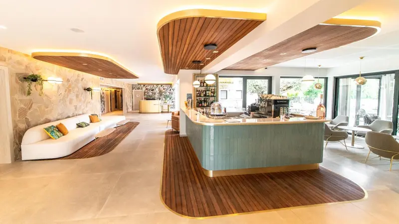 Un espace lumineux avec un long comptoir et des canapés blancs.
