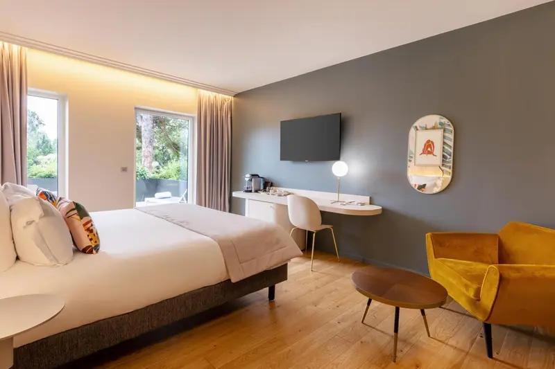 Une chambre lumineuse avec un grand lit et un espace bureau.