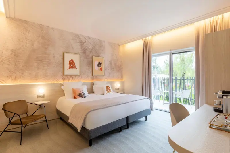 Une chambre lumineuse avec un lit double et un accès à une terrasse.