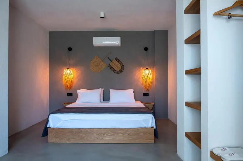 Une chambre lumineuse avec un grand lit et des suspensions décoratives.