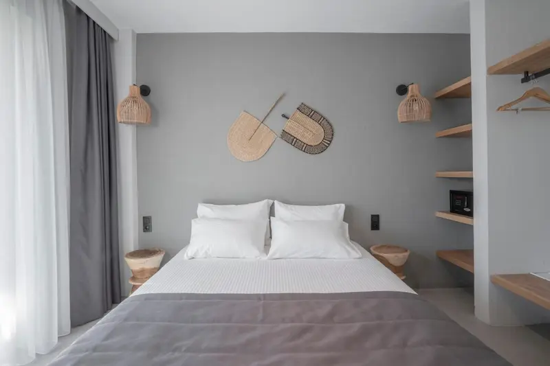 Une chambre lumineuse avec un grand lit recouvert de linge blanc.