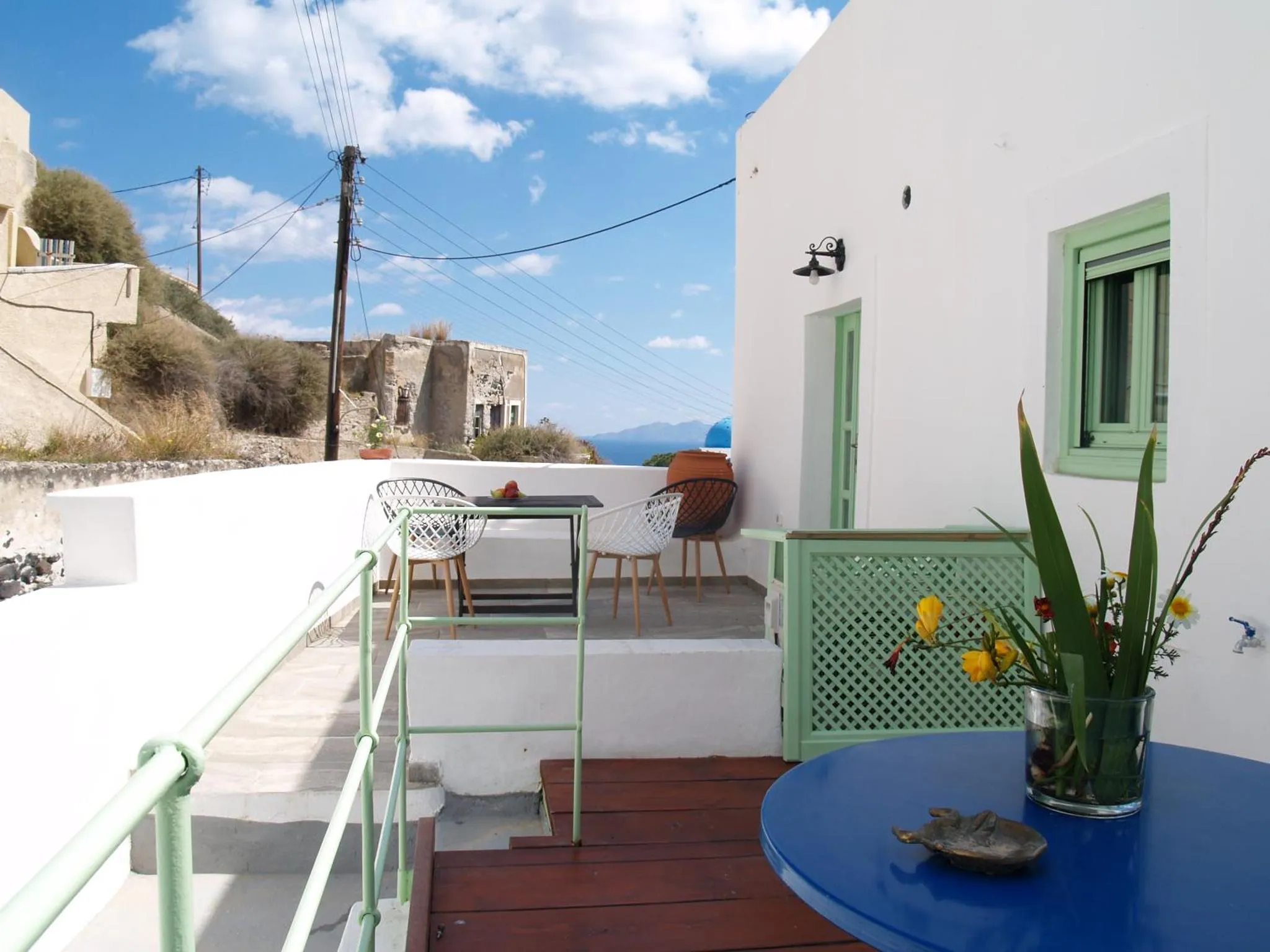 Terrasse avec mobilier de jardin et vue sur la mer.