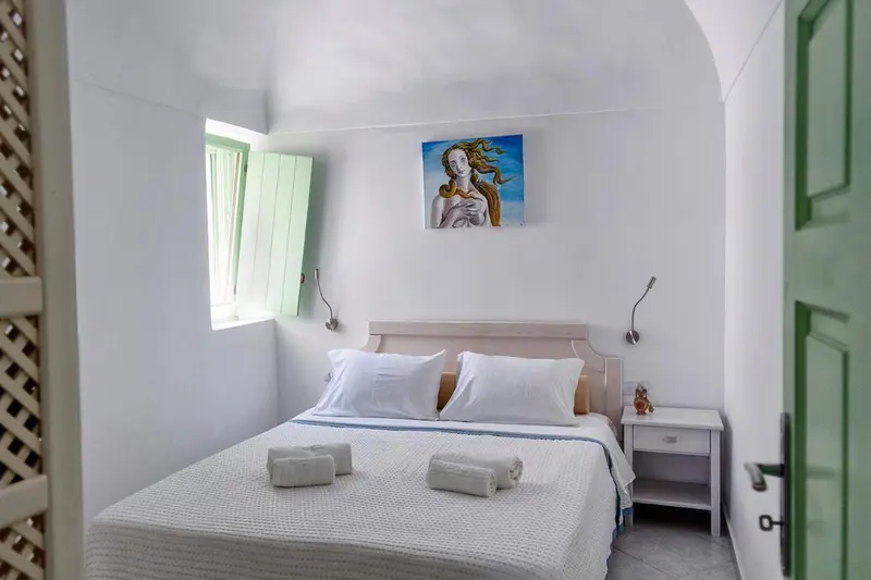 Une chambre lumineuse avec un lit double et une décoration murale.