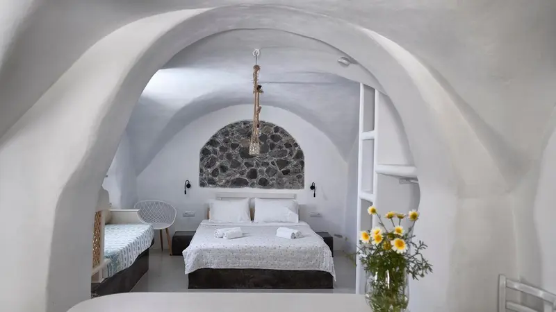Une chambre à coucher lumineuse avec un lit fait et une décoration minimaliste.