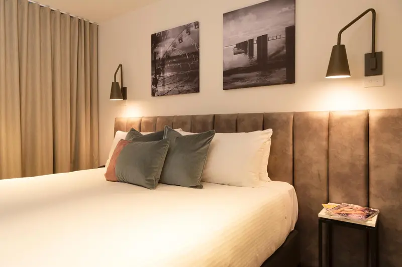 Une chambre à coucher avec un grand lit recouvert d'oreillers et de couvertures.