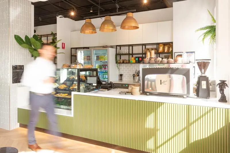 Un comptoir de café moderne avec des pâtisseries et des boissons.