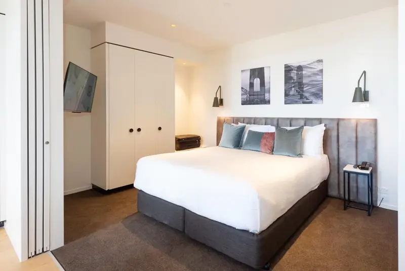 Une chambre lumineuse avec un grand lit et une décoration sobre.