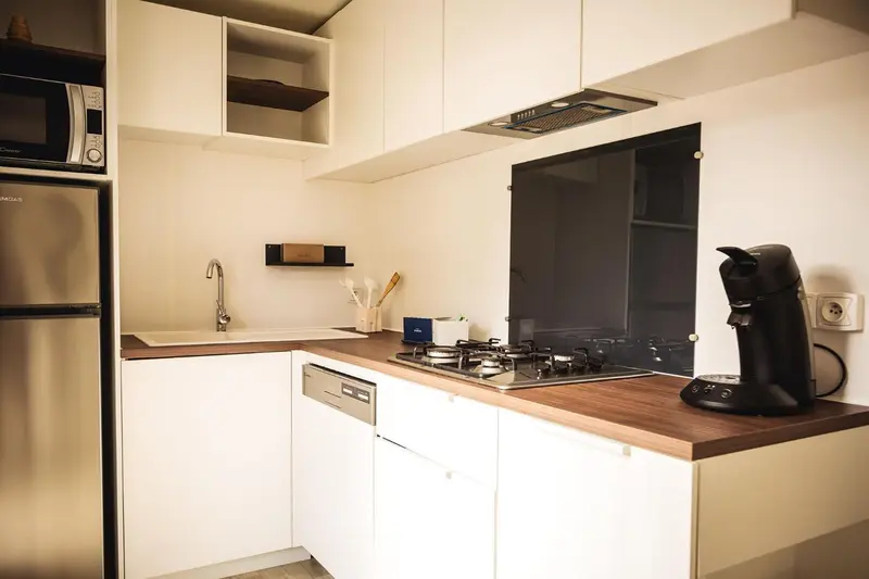 Une cuisine moderne avec un plan de travail en bois et des appareils électroménagers en acier inoxydable.