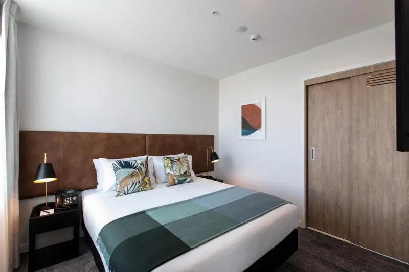 Une chambre lumineuse avec un grand lit et une décoration moderne.