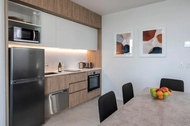 Une cuisine moderne avec un réfrigérateur, un four et une table à manger.