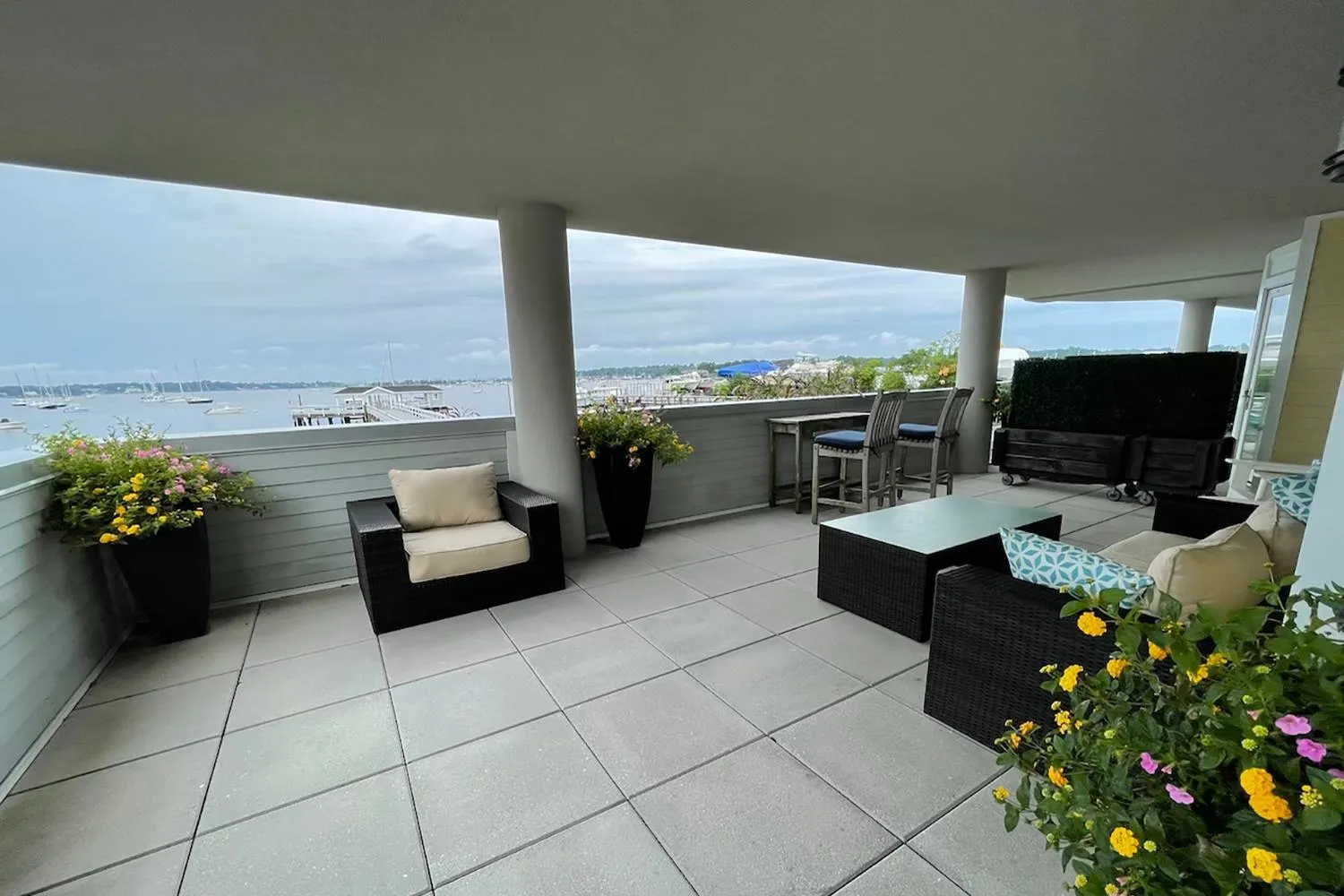 Terrasse aménagée avec mobilier d'extérieur et vue sur la mer.