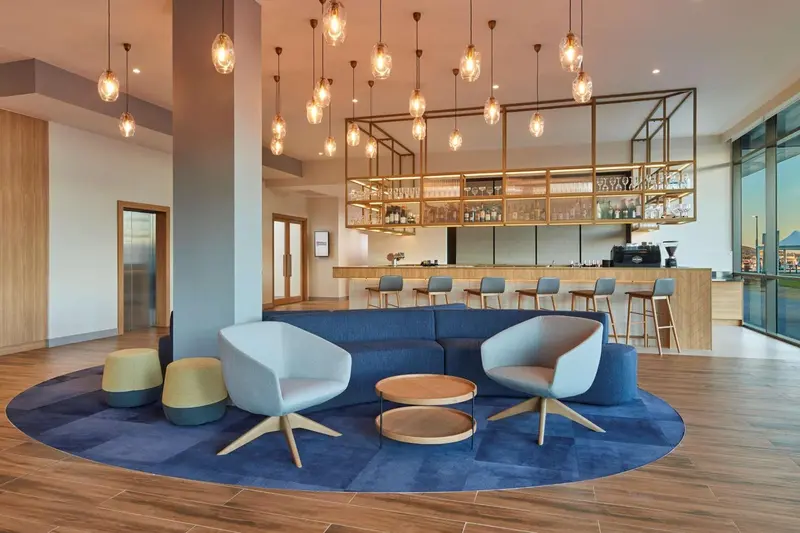 Un espace de détente avec des fauteuils et un bar en arrière-plan.