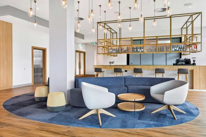 Un espace de détente avec canapés et fauteuils près d'un bar.