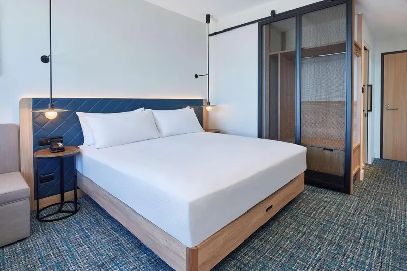 Une chambre d'hôtel moderne avec un grand lit et une décoration sobre.