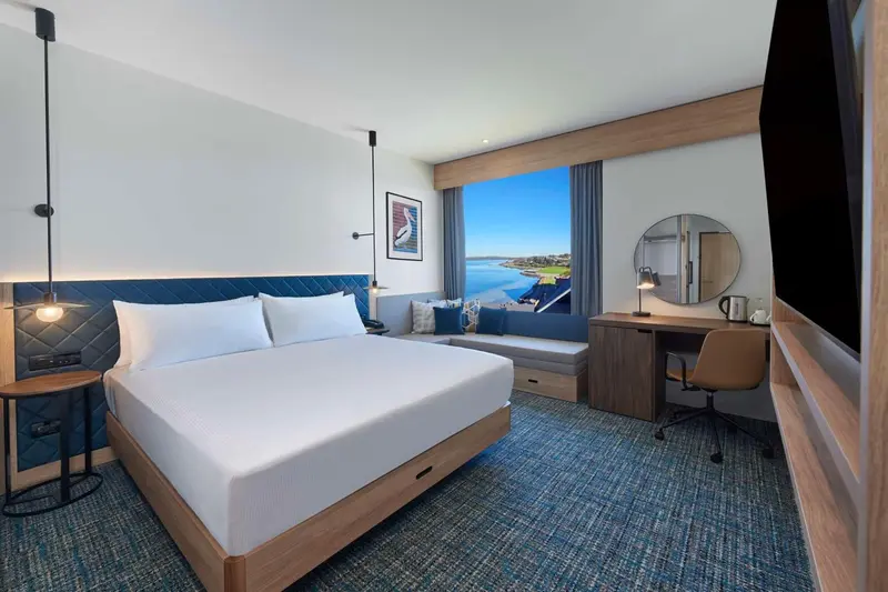 Une chambre lumineuse avec un grand lit et une vue sur la mer.