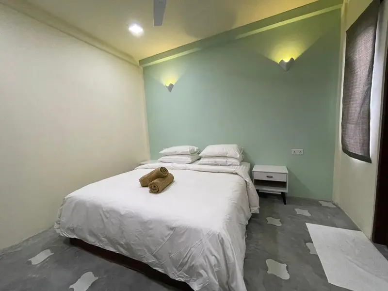 Une chambre lumineuse avec un grand lit recouvert de draps blancs.